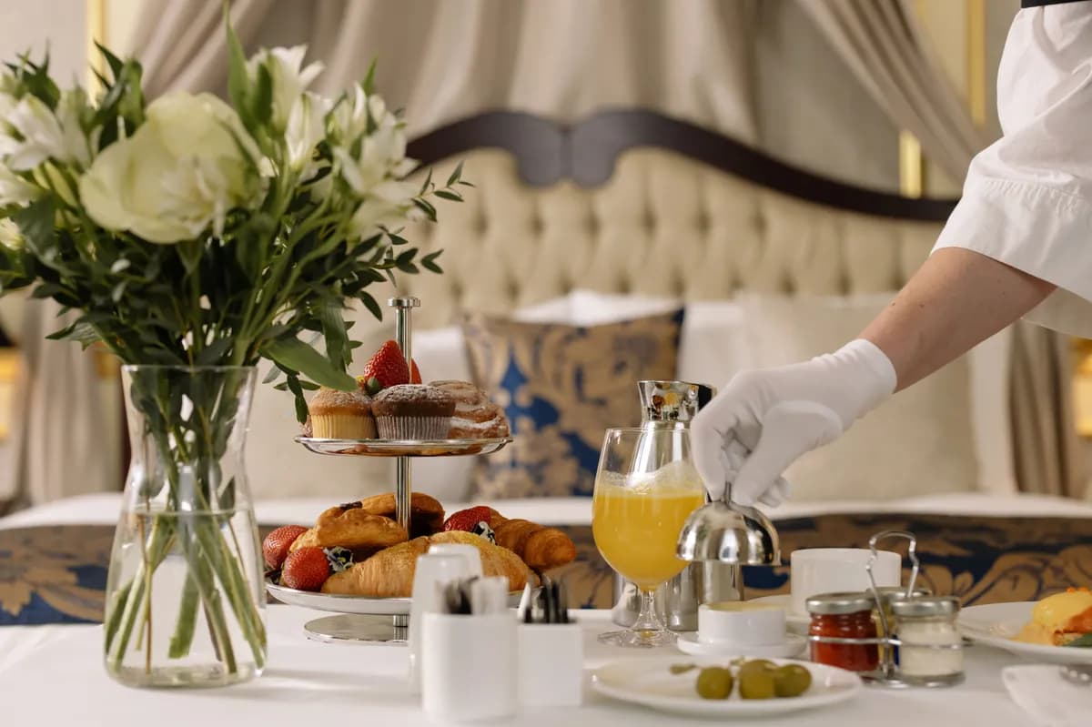 Exemple d'image BookNoFees : table du petit-déjeuner avec des viennoiseries, des fleurs et un verre de jus d'orange