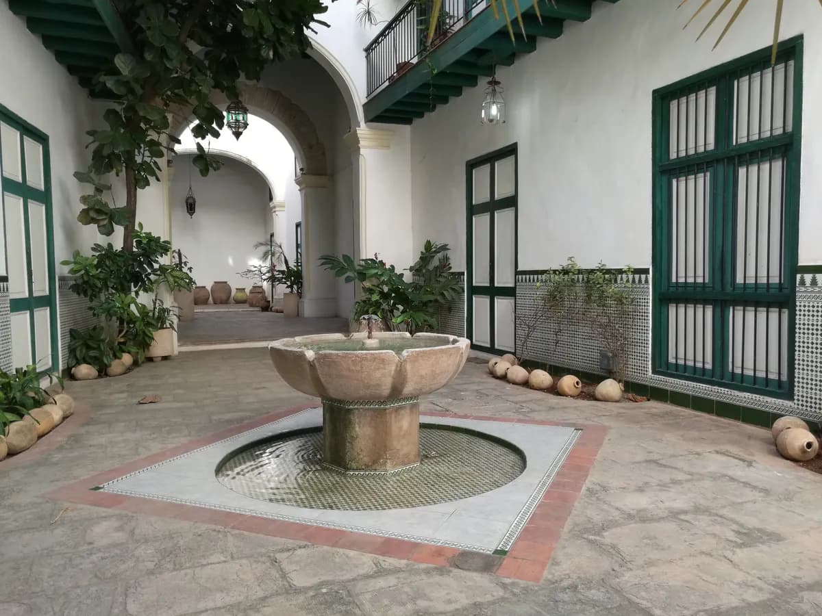 Exemple d'image BookNoFees : cour intérieure cubaine avec une fontaine et des portes peintes en vert