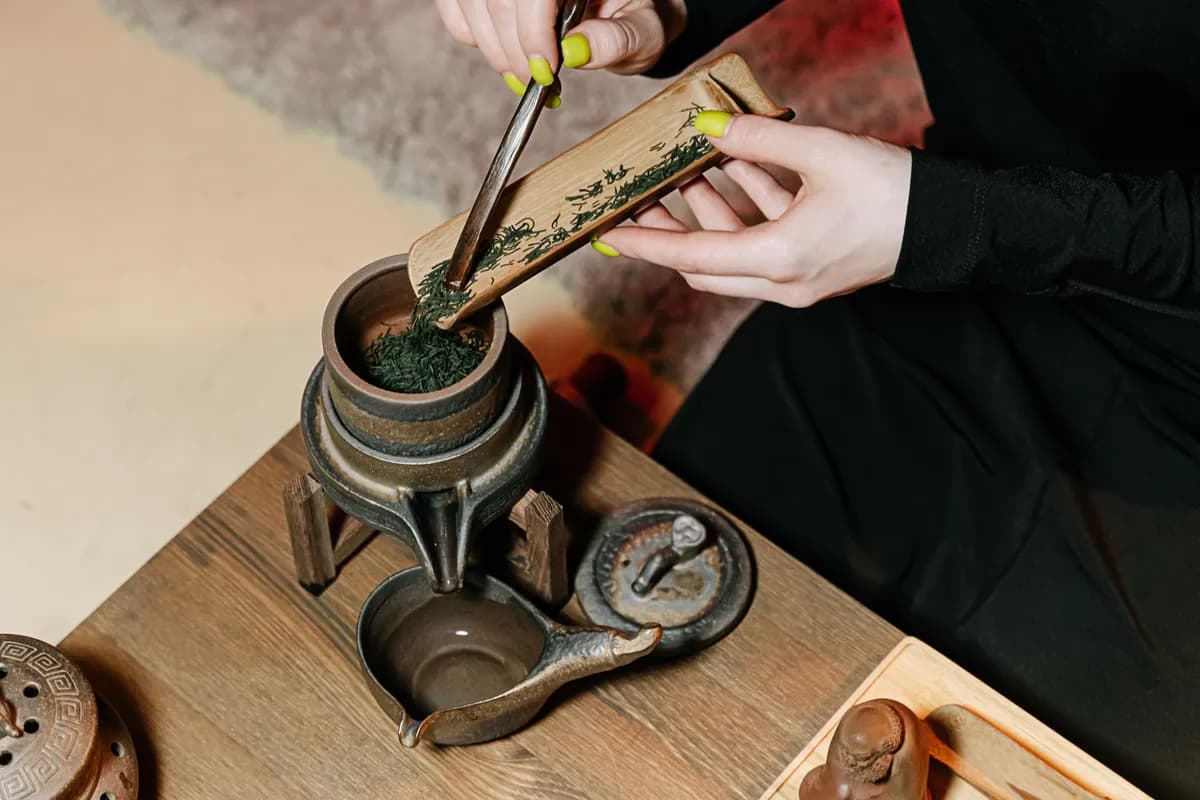 Exemple d'image BookNoFees : des mains en train de préparer du thé avec une cuillère en bambou