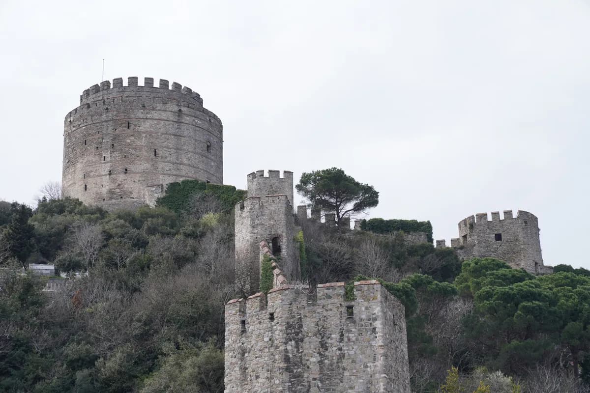 Exemple d'image BookNoFees : tour ronde en pierre avec des remparts, située sur une colline verdoyante