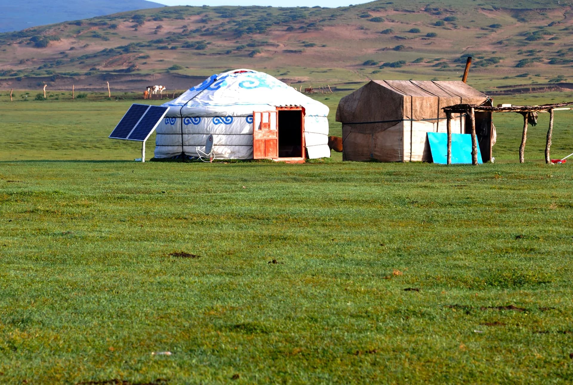 Exemple d'image BookNoFees : yourte ronde avec une porte décorée, située dans une vaste prairie