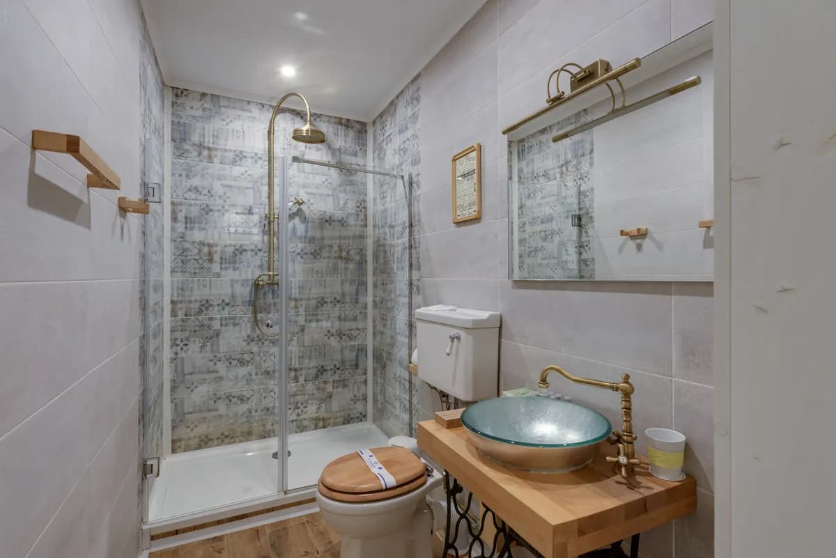 Exemple d'image BookNoFees : salle de bains avec douche vitrée et lavabo posé sur un meuble en bois