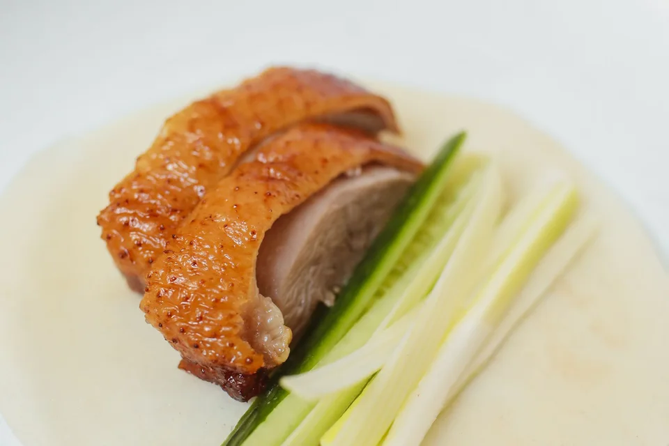 BookNoFees: Photo d’illustration : Canard laqué croustillant accompagné de concombres et d'oignons nouveaux, servi sur une fine crêpe