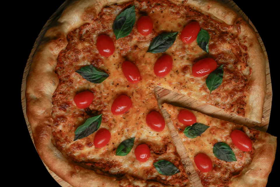 BookNoFees: Photo d’illustration : Pizza garnie de tomates et de basilic