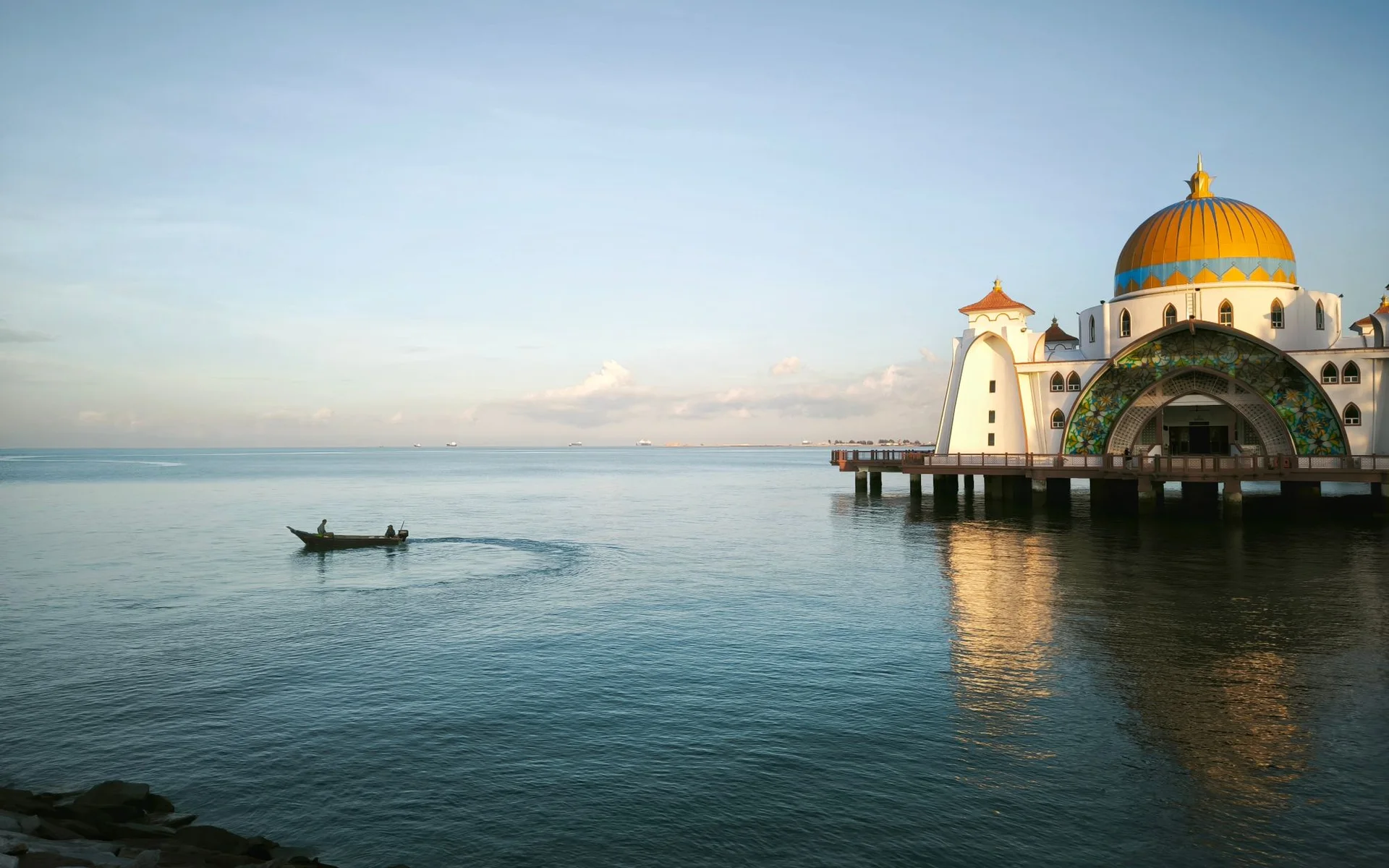 La mosquée de la rue Malakka et un bateau de pêche au bord de l’eau