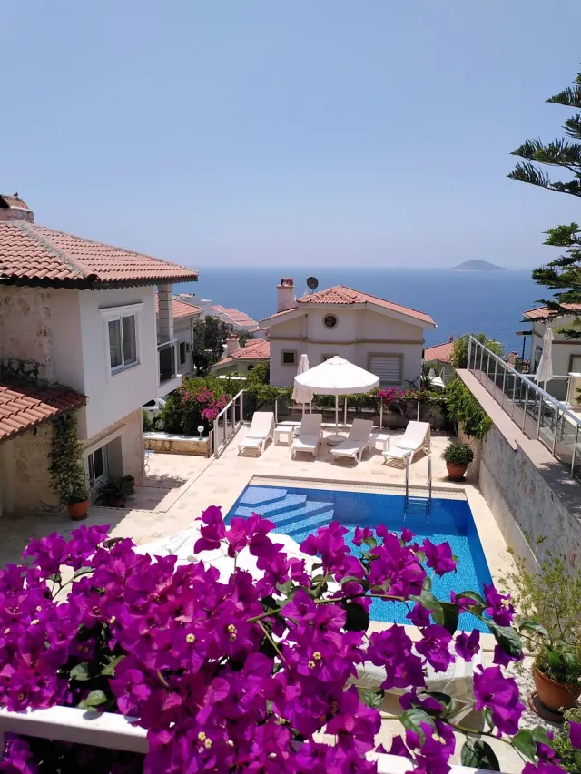 BookNoFees : location de vacances à Kalkan, Kas, Antalya, Antalya, Turquie – Terrasse avec piscine, transats, parasol et vue sur la mer