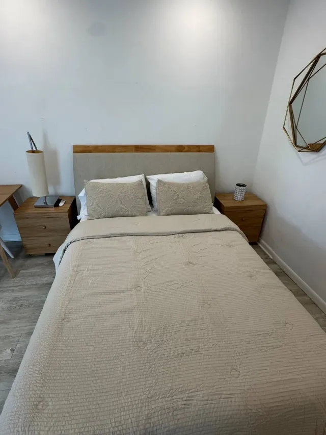 BookNoFees : location de vacances à Cutler Bay – Chambre à coucher avec un lit double, des tables de chevet en bois et un miroir mural aux motifs géométriques