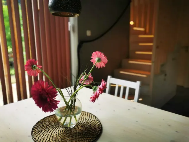BookNoFees : location de vacances à Hieflau, Styrie, Autriche – Coin repas avec une table blanche, un vase de fleurs roses et un escalier en bois