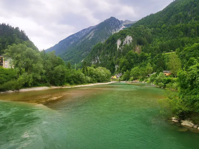 BookNoFees : location de vacances à Hieflau, Styrie, Autriche – Vue sur la rivière, avec des montagnes boisées et une maison jaune au bord de l'eau