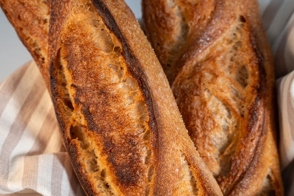 BookNoFees: Photo d’illustration : Des baguettes dorées posées sur une nappe à carreaux
