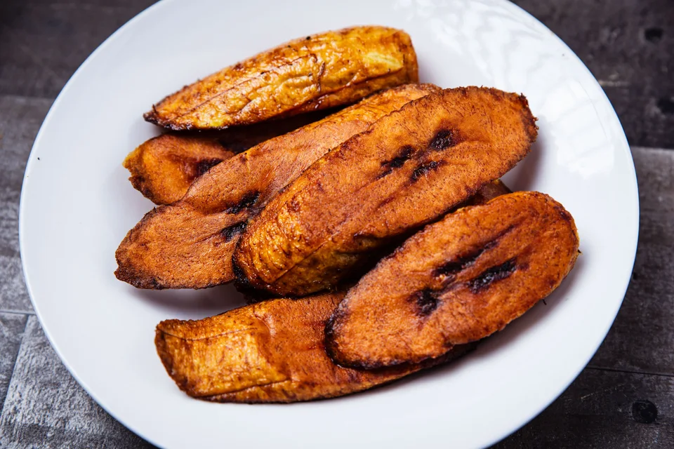 BookNoFees: Photo d’illustration : Tranches de banane plantain frites sur une assiette blanche