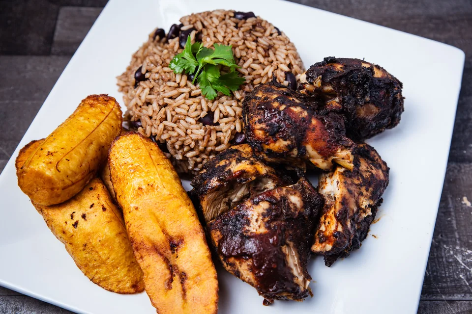 BookNoFees: Photo d’illustration : Poulet jerk accompagné de riz et de bananes plantains frites