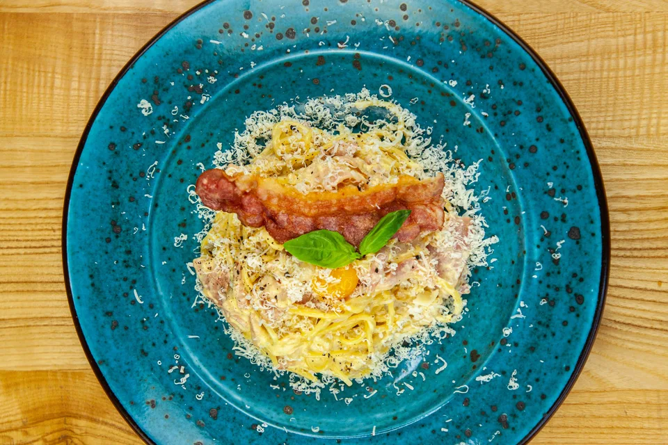 BookNoFees: Photo d’illustration : Spaghetti carbonara dans une assiette bleue